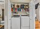 Convenient laundry closet with washer, dryer, storage shelves, and additional cleaning supplies at 8754 Brindisi Park Ave, Las Vegas, NV 89148