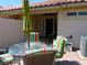 Inviting backyard patio with dining table, colorful chairs, and an umbrella for shade at 9705 Templemore Ave # 102, Las Vegas, NV 89129