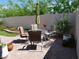 Landscaped backyard featuring a dining table, potted plants, and lush greenery at 9705 Templemore Ave # 102, Las Vegas, NV 89129