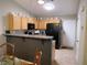 Functional kitchen with light wood cabinets, a breakfast bar, and modern appliances at 9705 Templemore Ave # 102, Las Vegas, NV 89129