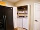 Convenient laundry area located near the kitchen with washer, dryer, and shelving for storage at 9705 Templemore Ave # 102, Las Vegas, NV 89129