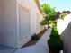 Home's walkway with neat landscaping, shrubs, and a privacy wall at 9705 Templemore Ave # 102, Las Vegas, NV 89129