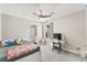 Well lit bedroom with a ceiling fan, desk, and carpet flooring with an adjoining bathroom at 10101 Heron Lake Ave, Las Vegas, NV 89178