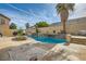 Backyard pool with a stone water feature, mature palm trees and patio space at 104 Glendive St, Henderson, NV 89012