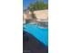 Backyard oasis featuring a pool, tanning shelf, waterfall features, and lush landscaping perfect for entertaining at 104 Glendive St, Henderson, NV 89012