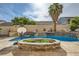 Backyard oasis featuring a pool, tanning shelf, waterfall features, and lush landscaping perfect for entertaining at 104 Glendive St, Henderson, NV 89012