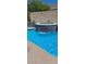 Backyard oasis featuring a pool, tanning shelf, waterfall features, and lush landscaping perfect for entertaining at 104 Glendive St, Henderson, NV 89012