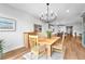 Bright dining room features modern chandelier, wood floors, and seating for four at 10601 Skye Arroyo Ave, Las Vegas, NV 89166