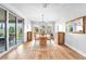 Bright dining room with a modern chandelier, sliding glass doors, and wood-look flooring at 10601 Skye Arroyo Ave, Las Vegas, NV 89166