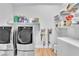 Bright laundry room with modern washer and dryer and ample shelving at 10601 Skye Arroyo Ave, Las Vegas, NV 89166