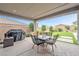 Covered patio with outdoor dining and grilling space, plus lovely backyard view at 10601 Skye Arroyo Ave, Las Vegas, NV 89166
