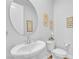 Charming powder room with pedestal sink, decorative mirror, and elegant fixtures, perfect for guests at 10601 Skye Arroyo Ave, Las Vegas, NV 89166