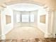 Bright and airy living room with neutral carpeting, large windows, and decorative pillars at 10816 Elm Ridge Ave, Las Vegas, NV 89144