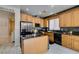 Well lit kitchen with stainless steel appliances, granite counters, kitchen island and light wood cabinets at 11004 Napa Ridge Dr, Las Vegas, NV 89144