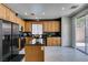Well lit kitchen with stainless steel appliances, granite counters, kitchen island and light wood cabinets at 11004 Napa Ridge Dr, Las Vegas, NV 89144