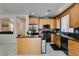 Well lit kitchen with stainless steel appliances, granite counters, kitchen island and light wood cabinets at 11004 Napa Ridge Dr, Las Vegas, NV 89144