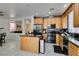 Well lit kitchen with stainless steel appliances, granite counters, kitchen island and light wood cabinets at 11004 Napa Ridge Dr, Las Vegas, NV 89144