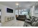 Bright living room featuring tiled floors, a media cabinet and a reclining sofa with cup holders at 11004 Napa Ridge Dr, Las Vegas, NV 89144
