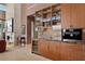 Elegant bar area featuring custom cabinets, marble countertops, and a wine refrigerator at 11707 Discovery Canyon Dr, Las Vegas, NV 89135