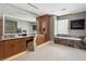 This primary bathroom boasts wood cabinets, a marble countertop and backsplash, and a soaking tub at 11707 Discovery Canyon Dr, Las Vegas, NV 89135