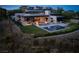 Stunning view of the backyard with a pool, lush lawn, and modern patio furniture at 11707 Discovery Canyon Dr, Las Vegas, NV 89135