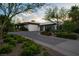 Contemporary home with a circular driveway, lush landscaping, and an attached two-car garage at 11707 Discovery Canyon Dr, Las Vegas, NV 89135
