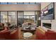 A living room featuring hardwood floors, a fireplace, and large windows that bring in ample natural light and views at 11707 Discovery Canyon Dr, Las Vegas, NV 89135