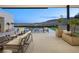 Relaxing backyard featuring a pristine pool, lounge chairs, and panoramic desert views beyond the trees at 11707 Discovery Canyon Dr, Las Vegas, NV 89135