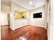 Living room featuring hardwood floors, large tv, and seamless flow to the kitchen at 1201 Dusty Creek St, Las Vegas, NV 89128