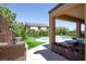 Beautiful backyard oasis with covered patio, built-in grill, lush landscaping, and refreshing pool at 176 Jay Porter Ave, Henderson, NV 89002