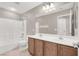 Well lit bathroom with double vanity, shower-tub combo, and light tile flooring at 176 Jay Porter Ave, Henderson, NV 89002