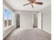 Bedroom with neutral walls, carpet, ceiling fan, and a window overlooking nearby houses at 176 Jay Porter Ave, Henderson, NV 89002