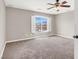 Bright bedroom with ceiling fan, carpeted floors, and views of the neighborhood through shuttered windows at 176 Jay Porter Ave, Henderson, NV 89002