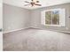 Neutral bedroom featuring a ceiling fan, carpeted floors, and a bright window with shutters and views at 176 Jay Porter Ave, Henderson, NV 89002