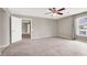 Spacious carpeted bedroom featuring a ceiling fan, neutral walls, and natural light from the window at 176 Jay Porter Ave, Henderson, NV 89002