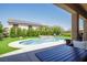 Backyard oasis featuring pool with green artificial grass, solar panels, and covered patio at 176 Jay Porter Ave, Henderson, NV 89002