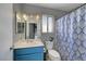 Bathroom featuring a sink, mirror, blue vanity, toilet, and a patterned shower curtain at 1809 Solana Del Norte Way, North Las Vegas, NV 89031