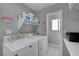 Functional laundry room with white washer and dryer, storage shelf, and clean, neutral tones at 1809 Solana Del Norte Way, North Las Vegas, NV 89031