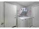 Functional laundry room with white washer and dryer, storage shelf, and clean, neutral tones at 1809 Solana Del Norte Way, North Las Vegas, NV 89031