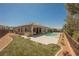 A spacious backyard features a pristine pool, lush lawn, and desert landscaping at 2177 Magnolia Pond Ct, Henderson, NV 89052