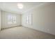 This bedroom features neutral carpeting, two windows, and tray ceilings at 2177 Magnolia Pond Ct, Henderson, NV 89052