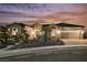 Exterior front view of the home at dusk showing the desert landscaping, facade, and three-car garage at 2177 Magnolia Pond Ct, Henderson, NV 89052