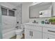 Bathroom features a vanity with black hardware, a framed mirror, and a tiled tub-shower combo at 2211 Frontier Ave, Las Vegas, NV 89106