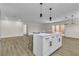 Open-concept living room with kitchen island, modern lighting, and access to the outdoors through french doors at 2211 Frontier Ave, Las Vegas, NV 89106