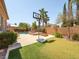 Inviting backyard with artificial grass, a basketball court, a pool, and mature palm trees at 2382 Sunburst View St, Henderson, NV 89052