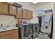 Well-equipped laundry room with modern washer and dryer, sink, and ample cabinet storage at 2382 Sunburst View St, Henderson, NV 89052