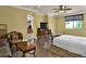 Spacious main bedroom with a ceiling fan, dark wood floors, and a large window providing ample natural light at 2382 Sunburst View St, Henderson, NV 89052