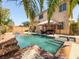 Backyard swimming pool and spa featuring a rock waterfall and mature palm trees at 2382 Sunburst View St, Henderson, NV 89052