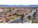 Wide aerial view showcasing a community of single-story homes with tile roofs against a mountain backdrop at 240 Vineyard Ln, Mesquite, NV 89027