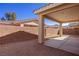Covered backyard patio area with desert landscaping and brick wall surround at 240 Vineyard Ln, Mesquite, NV 89027